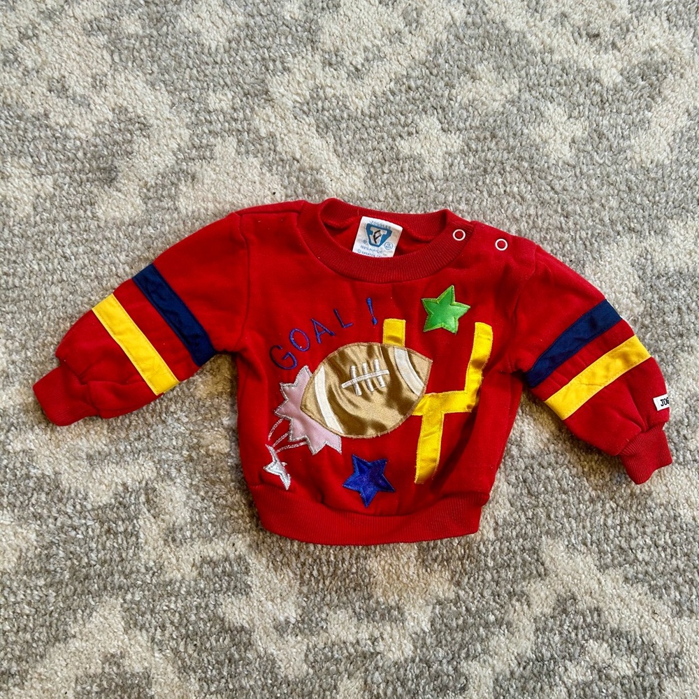 Vibrant Red Sweatshirt with Colorful Stripes and Football Design